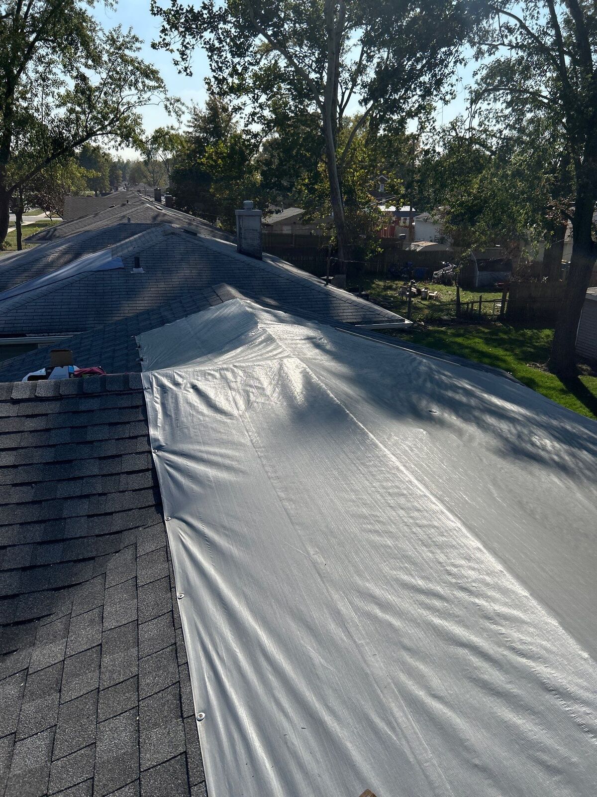 Storm-damaged roof covered with a protective tarp after a hurricane, on a recent Ripple client job
